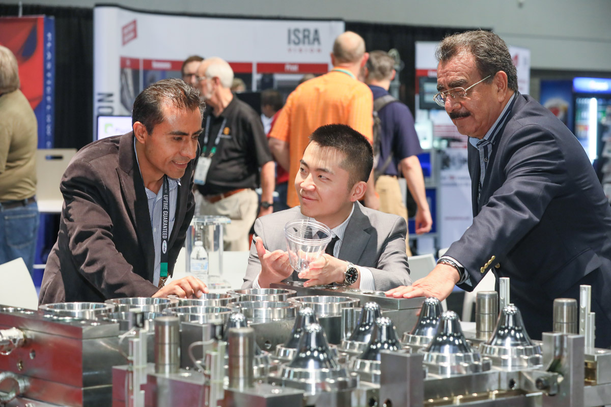 An exhibitor showing his product to an attendee at NPE